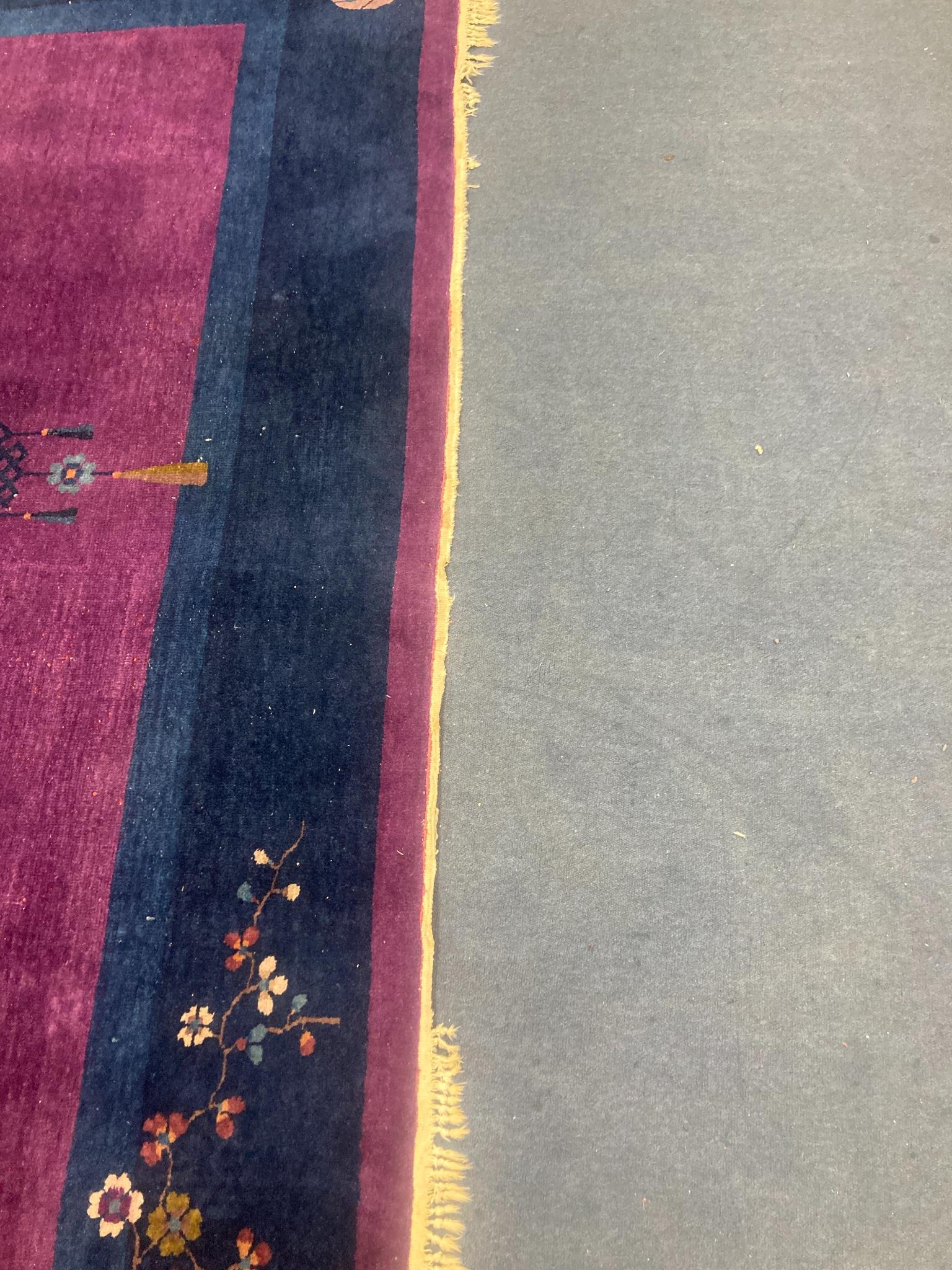 A large purple ground Chinese wool carpet, 342 x 276cm